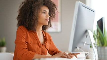 Cybersecurity 101: Woman sitting behind a desktop computer screen.